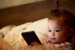 niño mirando la pantalla de un móvil, ¿cómo afecta eso a su salud?